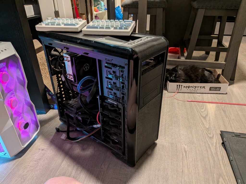Black open computer tower case open with keyboard on top